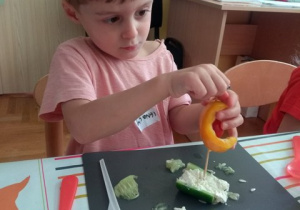 Chłopiec przygotowuje łódeczkę z warzyw